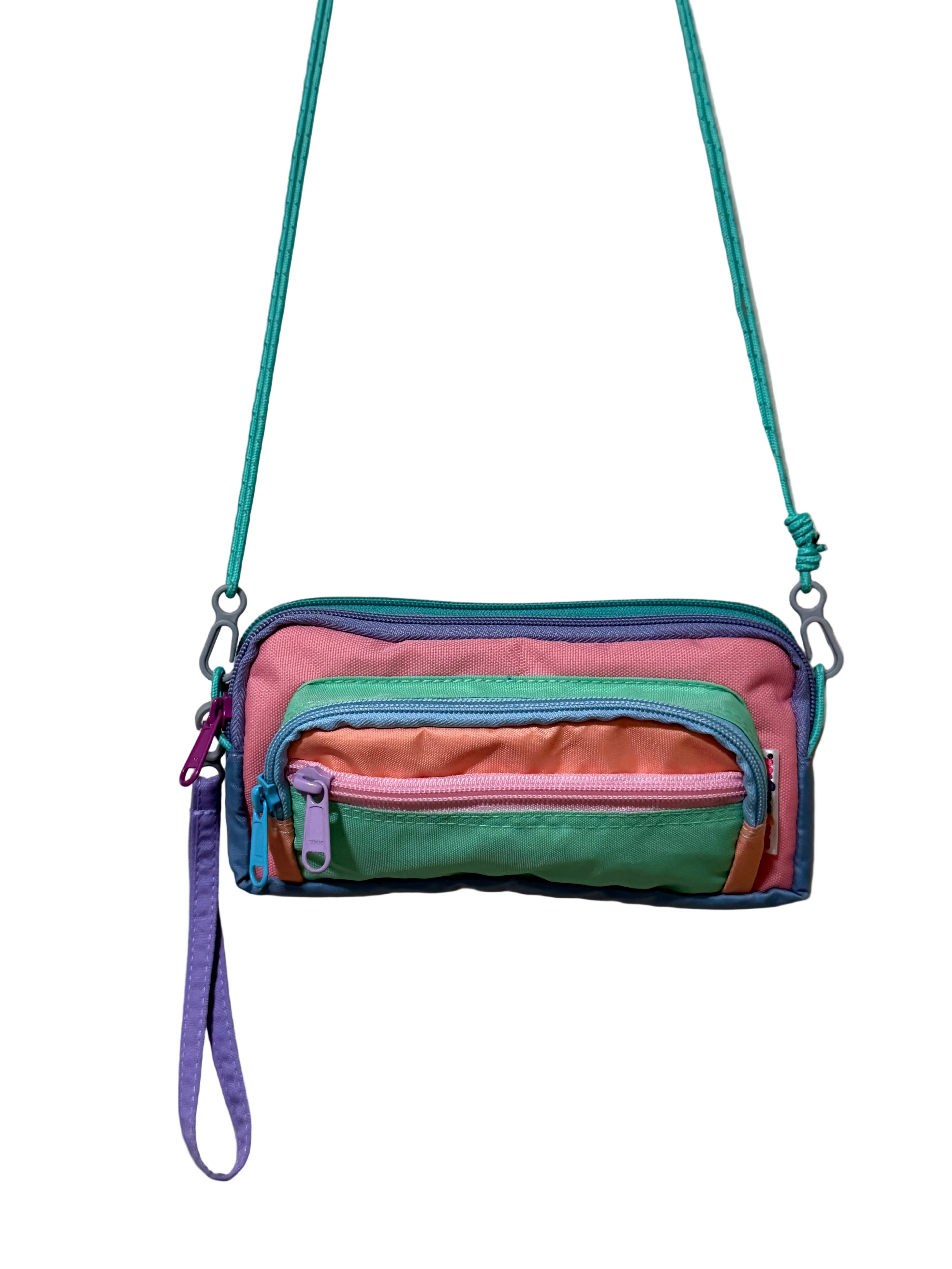 Multicolored crossbody bag with zippers on a beige background