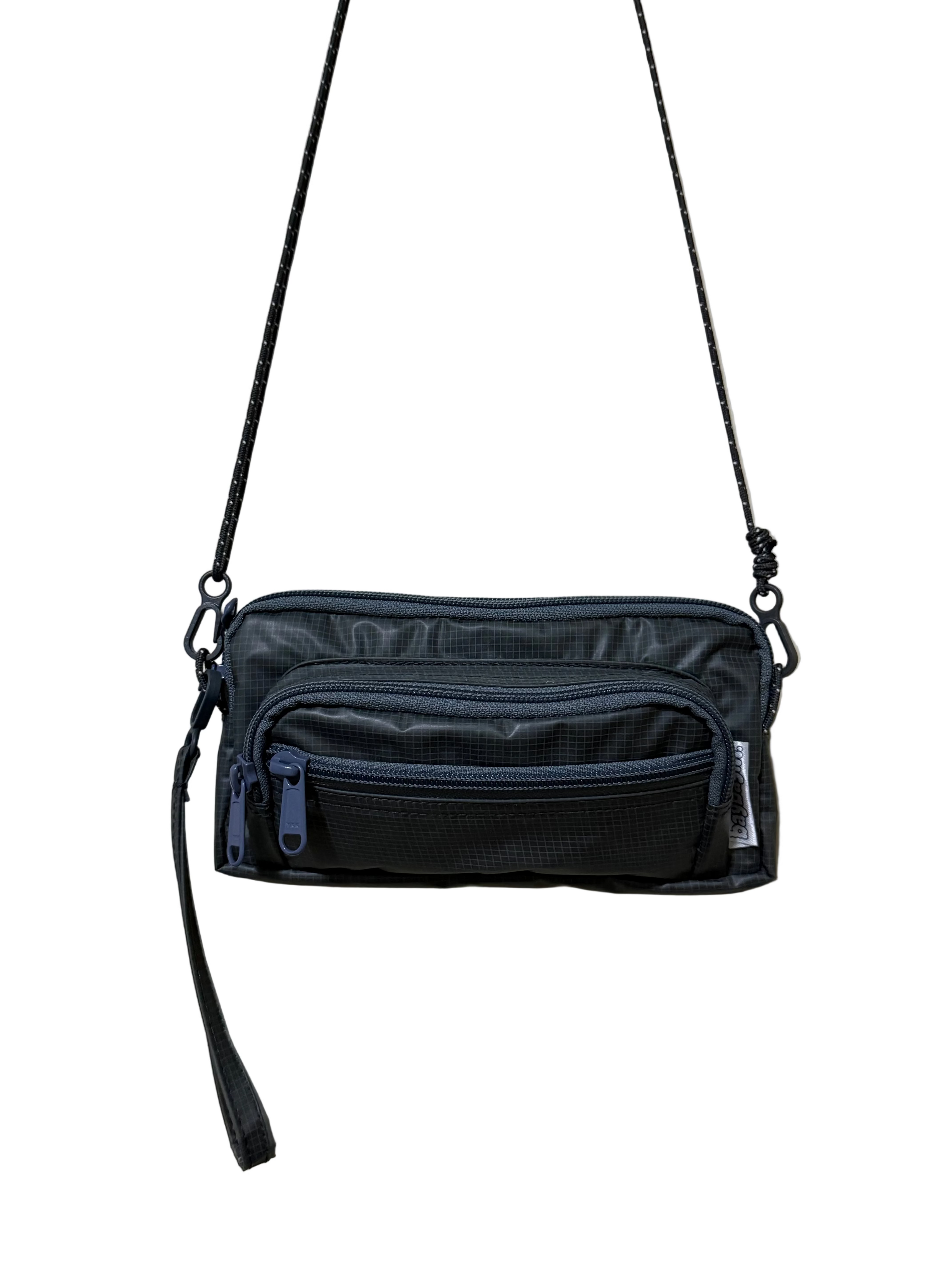Black crossbody bag on a beige background