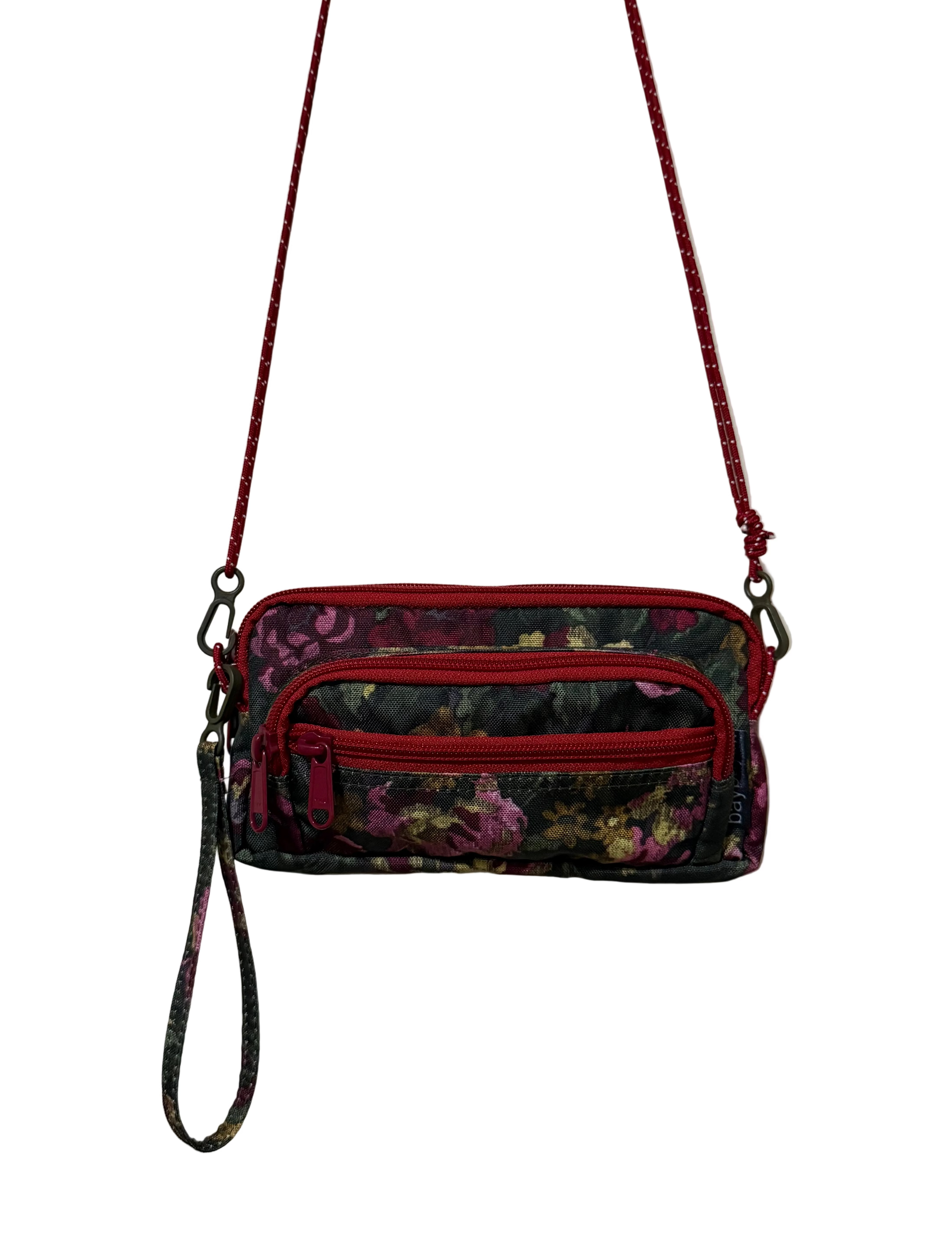Floral-patterned handbag with a red strap on a white background